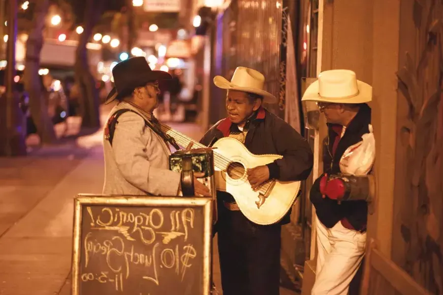 3 ican musicians perform on a street in the mission district of San Francisco.